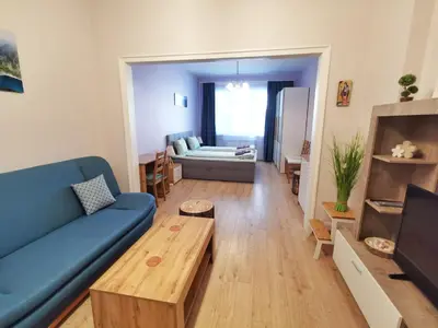 a living room with a blue couch and a table at Rila Apartment in Sofia