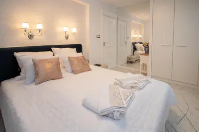 a bedroom with a white bed with towels on it at Paradise Center Premium Suite 2 in Sofia