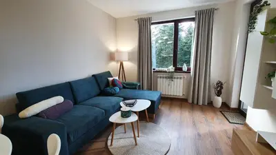a living room with a blue couch and a table at Borovets Holiday Homes in Borovets