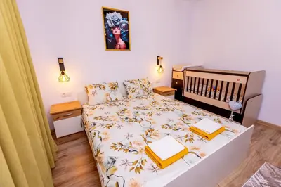 a small bedroom with a bed with yellow sheets at Къща за гости Калинови in Sandanski