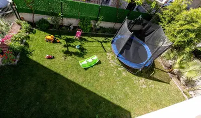 an overhead view of a backyard with an umbrella on the grass at Къща за гости Калинови in Sandanski