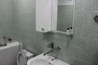 a bathroom with a sink and a mirror and a toilet at СТУДИО-ЛАМБО in Sandanski