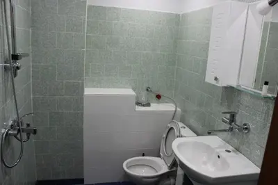 a bathroom with a toilet and a sink at СТУДИО-ЛАМБО in Sandanski