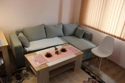 a living room with a blue couch and a table at СТУДИО-ЛАМБО in Sandanski