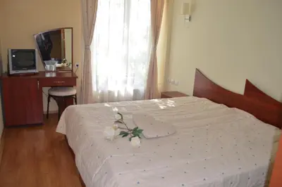 a bedroom with a bed with a flower arrangement on it at Hotel Shterev Karlovo in Karlovo