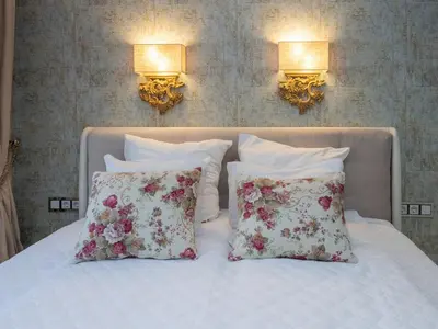 two pillows on a bed with two lights on the wall at Paradise Center Premium Suite 1 in Sofia