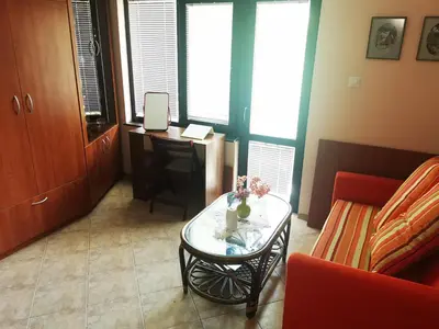 a living room with a table and a desk at Къщата на Румен in Sofia