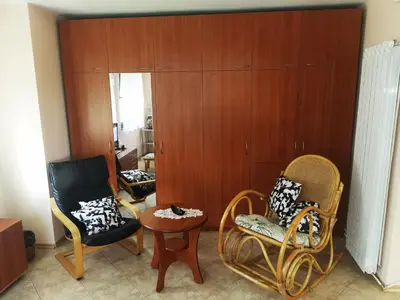 a living room with two chairs and a table at Къщата на Румен in Sofia