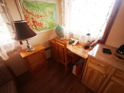 a desk in a room with a lamp and a window at Къщата на Румен in Sofia