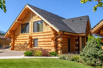 a log cabin with a black roof at Alpina Luxury Chalets in Banya