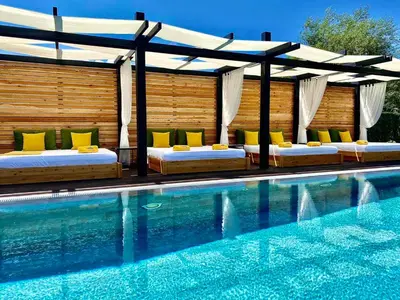a swimming pool with two beds and a canopy over a swimming pool at Alpina Luxury Chalets in Banya