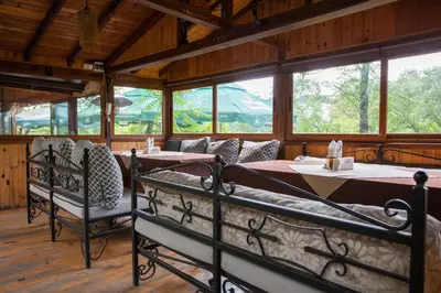 a dining room with two beds and windows at Бунгала Сън Сити in Sandanski