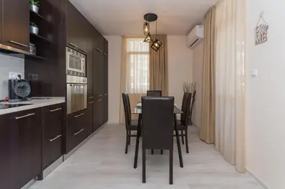 a kitchen with a table and chairs in a room at Alma Apartment - Stylish 1BD Flat with Balcony by Flat Mаnager in Plovdiv