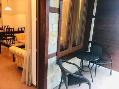 a balcony with two chairs and a table and a window at Luxury Downtown Apartment - Gondola in Bansko