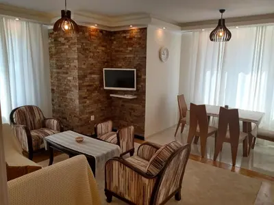 a living room with a table and chairs and a tv at Valentina Bg Apartment in Sofia