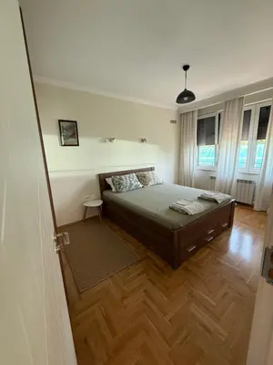 a bedroom with a bed and a wooden floor at Valentina Bg Apartment in Sofia