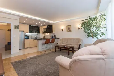 a living room with two couches and a kitchen at Apartment 