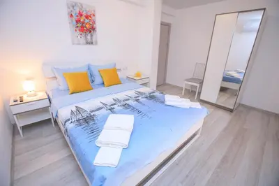 a bedroom with a large bed with towels on it at The Sun loves You - right beside the Park! in Sandanski