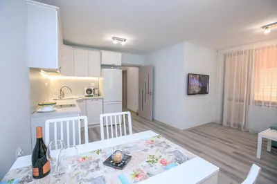 a kitchen and living room with a table and a kitchen and a dining room at The Sun loves You - right beside the Park! in Sandanski