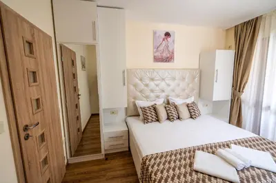 a bedroom with a large white bed and a door at Park Apartment Emilin in Sandanski