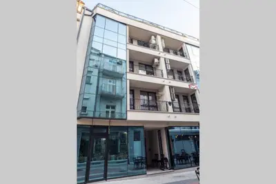 an apartment building with a reflection in the window at Elegance, City center, Kapana in Plovdiv