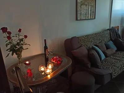 a living room with a couch and a table with flowers at Studio Anastasia in Sapareva Banya