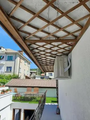 awning over a balcony with tables and chairs on a building at Родопчани Старцево in Starzewo