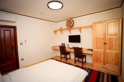 a bedroom with a bed and a desk with a television at Родопчани Старцево in Starzewo