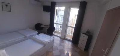 a bedroom with a white bed and a window at ПАИ Хост in Plovdiv