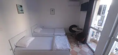 a small room with two beds and a window at ПАИ Хост in Plovdiv