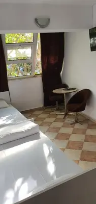 a room with a bed and a table and a window at ПАИ Хост in Plovdiv