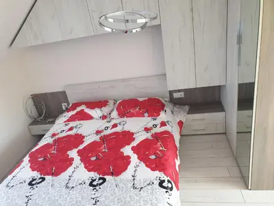 a bedroom with a bed with red flowers on it at Cosy Charming Apartment in Blagoevgrad