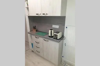 a kitchen with white cabinets and a toaster on a counter at Cosy Charming Apartment in Blagoevgrad