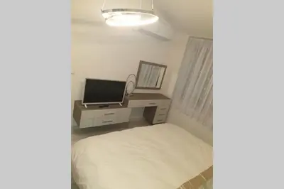 a bedroom with a bed and a desk with a television at Cosy Charming Apartment in Blagoevgrad