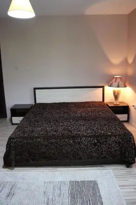 a bedroom with a large bed and a lamp at GREEN HOUSE - Попниколови in Sapareva Banya