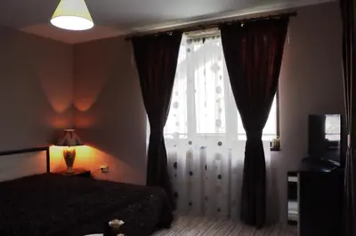 a bedroom with a bed and a window with curtains at GREEN HOUSE - Попниколови in Sapareva Banya