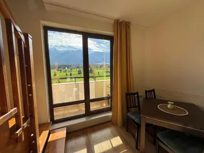 a room with a table and a large window at Sunny Duplex, Mountain Views, Spa Access, Near Bansko, Terra Complex in Razlog