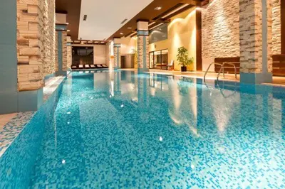 a large swimming pool with blue water in a building at Apartments B06 in TERRA complex in Razlog