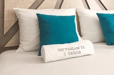 a pillow on a bed with blue and white pillows at ОРФЕЕВИТЕ ПЕСНИ in Devin