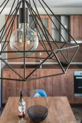 a glass light fixture hanging over a wooden table at ОРФЕЕВИТЕ ПЕСНИ in Devin