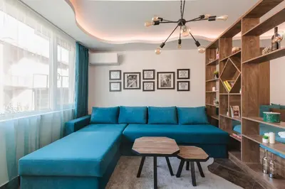a living room with a blue couch and a table at ОРФЕЕВИТЕ ПЕСНИ in Devin