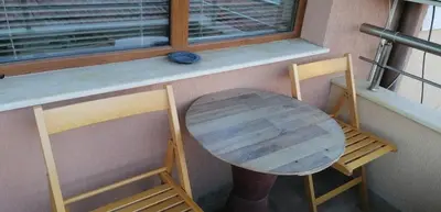 a table and two chairs sitting next to a window at Роден Край Homeland in Sopot