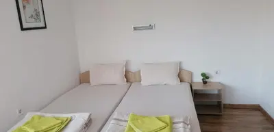 a white bed with two pillows on it in a room at Роден Край Homeland in Sopot