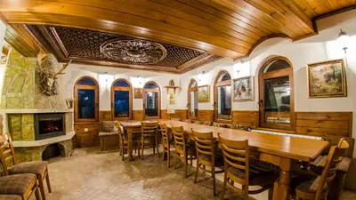 a dining room with a table and chairs and a fireplace at Къща за гости Черна река in Ribarica