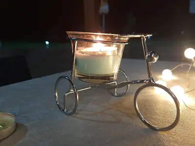 a candle in a glass jar on a table with lights at Вила МАЯ in Krayni Dol