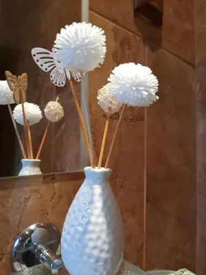 a white vase with white flowers in it at Вила МАЯ in Krayni Dol