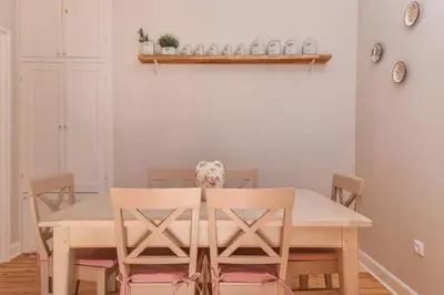 a dining room table with two chairs and a dog on it at Chez Marie - Cozy One-Bedroom with Balcony by Flat Mаnager in Sofia