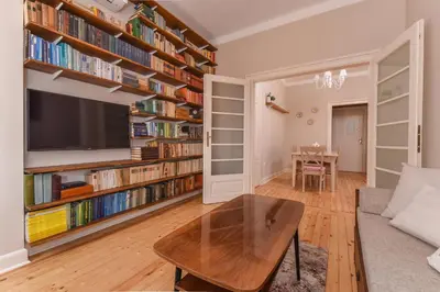 a living room with a couch and a table and books at Chez Marie - Cozy One-Bedroom with Balcony by Flat Mаnager in Sofia
