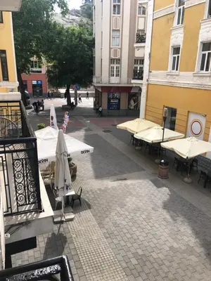 an empty courtyard with tables and umbrellas on a building at CENTER APARTMENT PLOVDIV in Plovdiv