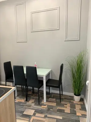 a dining room table with chairs and a white table at CENTER APARTMENT PLOVDIV in Plovdiv